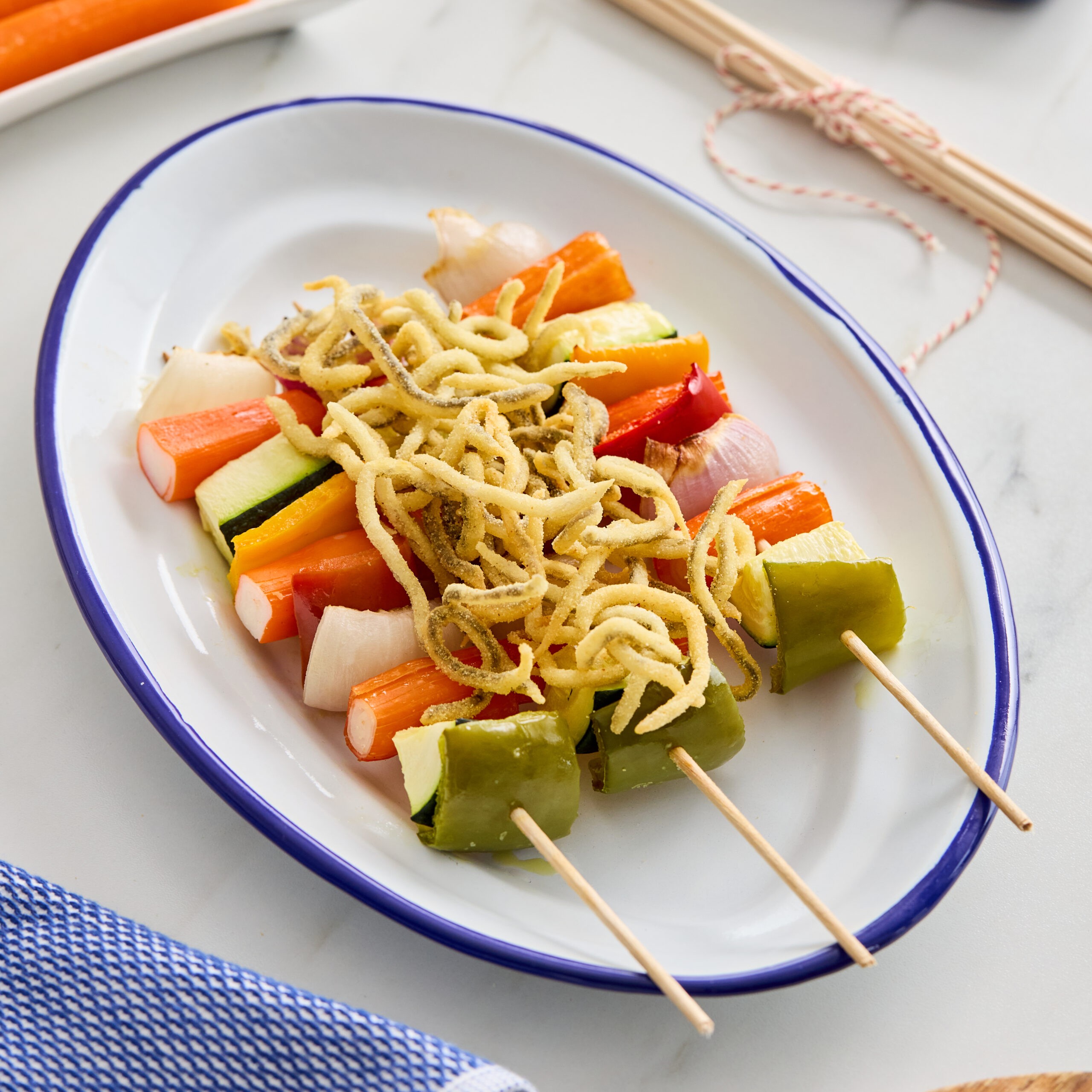 Brochetas de palitos de mar y vegetales con crujiente de anguriñas